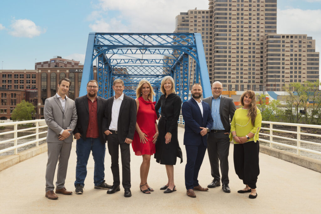 A picture of the Keystone Home Group team on a bridge with a city in the backdrop. 